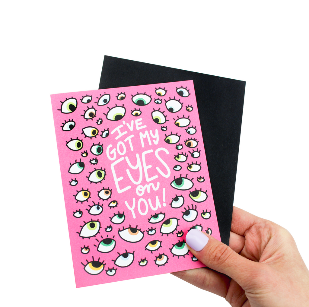 Pink card with multiple drawings of eyes and white text that reads "I've Got My Eyes on You."