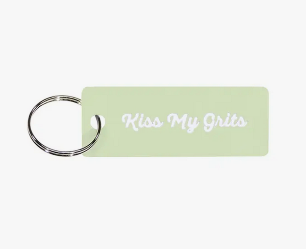 Kiss my grits keychain. White cursive lettering on light green background. 