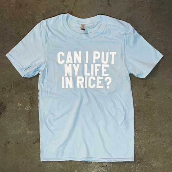 Light blue shirt with white text that reads "Can I put my life in rice?"