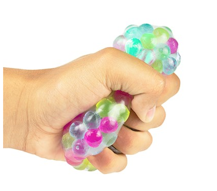 Hand squeezing a multicolored bead filled clear plastic ball.