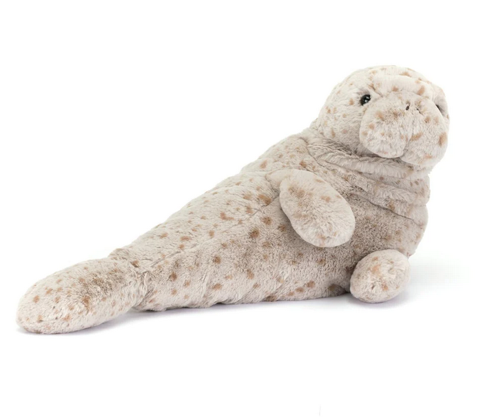 Magnus Manatee plush lounging on his side with his dappled fur. 