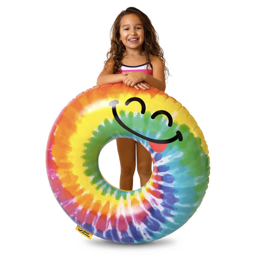 Child standing behind a smiling tie dyed ring float.
