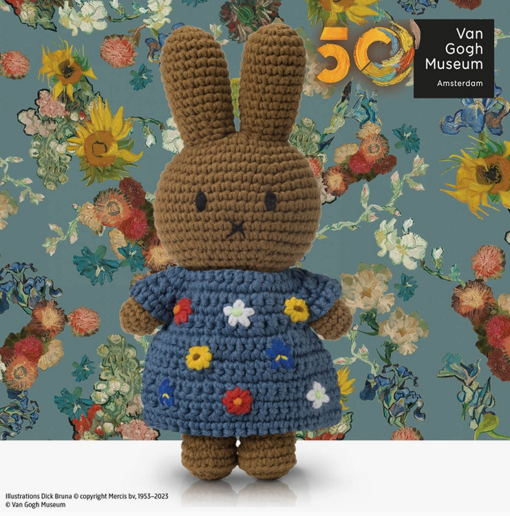 Melanie the crochet doll wearing a dress decorated with flowers inspired by Van Gogh. 