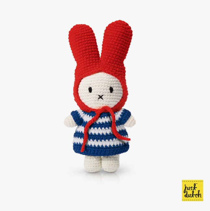 Miffy bunny crocheted doll wearing a navy and white striped dress and a red hat. 