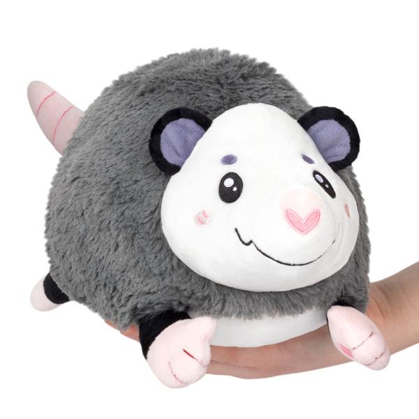 Super huggable plush mole. It's gray fur is soft and fluffy with a cute smiling face and purple ears. It's paws and tail are a pale pink.