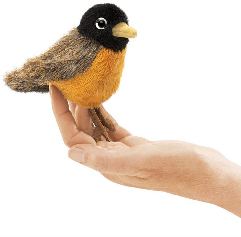 Hand holding a robin finger puppet. Robin is brown with a red belly and black head.