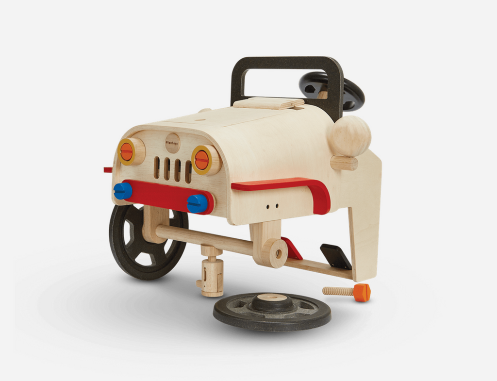 Large wooden construction toy front end of a car that child can use for pretend play while practicing wrench, hammer, and screwing skills.