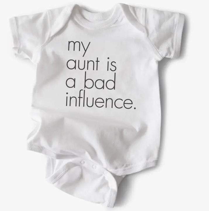 White baby onesie that reads " My Aunt is a bad influence". 