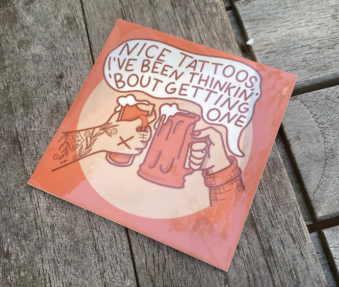 Sticker of two arms, one with tattoos and a soda, one with long sleeves and a beer with speech bubble that says Nice tattoos, I've been thinkin' 'bout getting one.