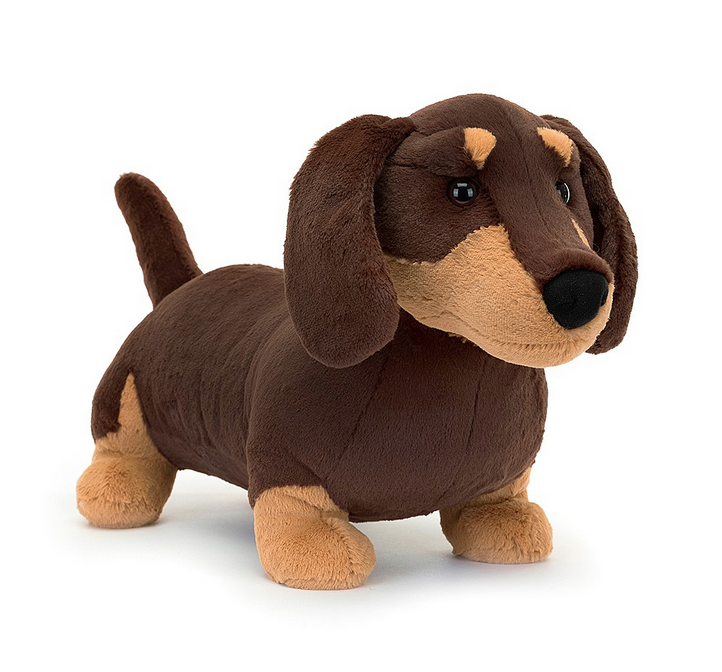 Otto Sausage Dog has tiny legs and dark chocolate fur with caramel patches. With waggly ears, a perky tail, golden eyebrows.