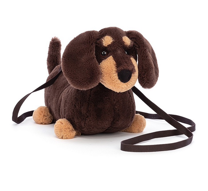 Otto Sausage Dog plush bag has biscuit paws, brows and snout, floppy ears, and hazel eyes. This bag also has a strong silver zip, a cross-body strap in cocoa webbing and matching cotton lining. 