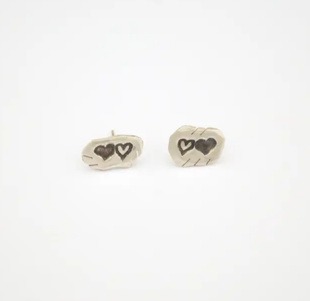 Small reclaimed silver stud earrings with two stamped hearts.