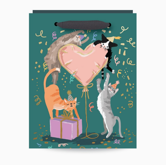 Party Kittens gift bag with a green background and illustration of a pink heart shaped balloon and confetti falling with four different kitty cats playing. 