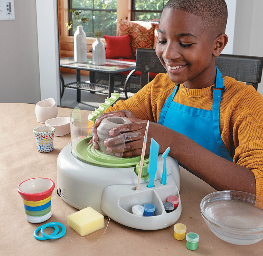 Young boy using pottery wheel.