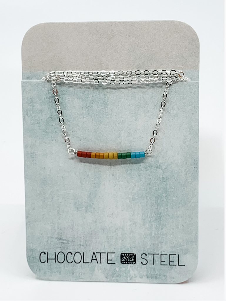 Silver chain necklace with a straight bar of rainblow colored beads.
