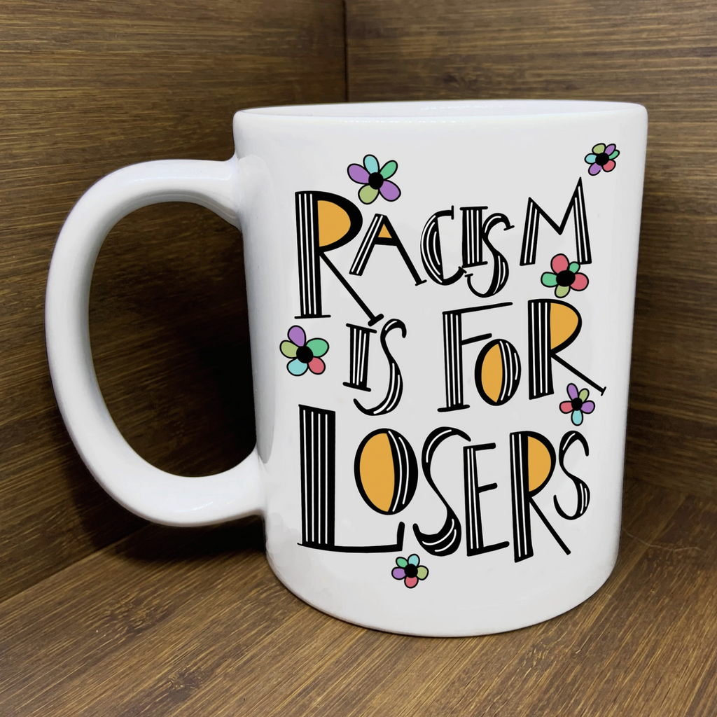 White mug with black text reading "Racism is For Losers."