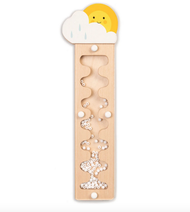 Wooden rain maker music maker. Maker is wooden thin rectangle topped with a smiling sun and rain cloud. Clear cutout down the middle show the white beads that make the rain noise.