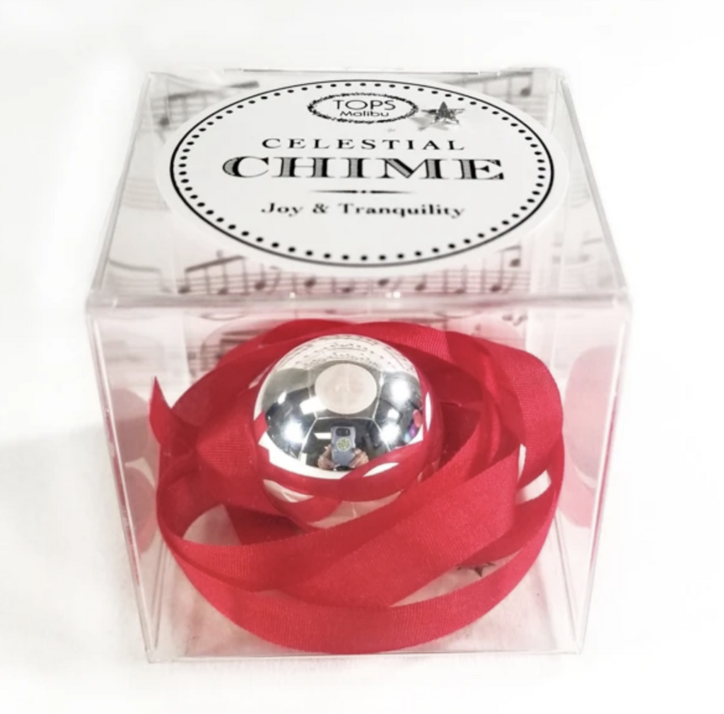 Silver ball chime on a red ribbon in a gift box.
