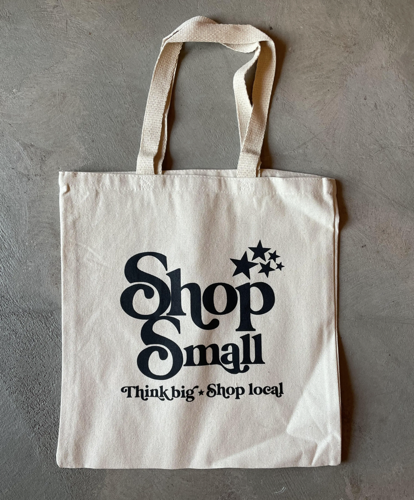 Tote bag that reads "Shop small. Think big. Shop local" in black text.