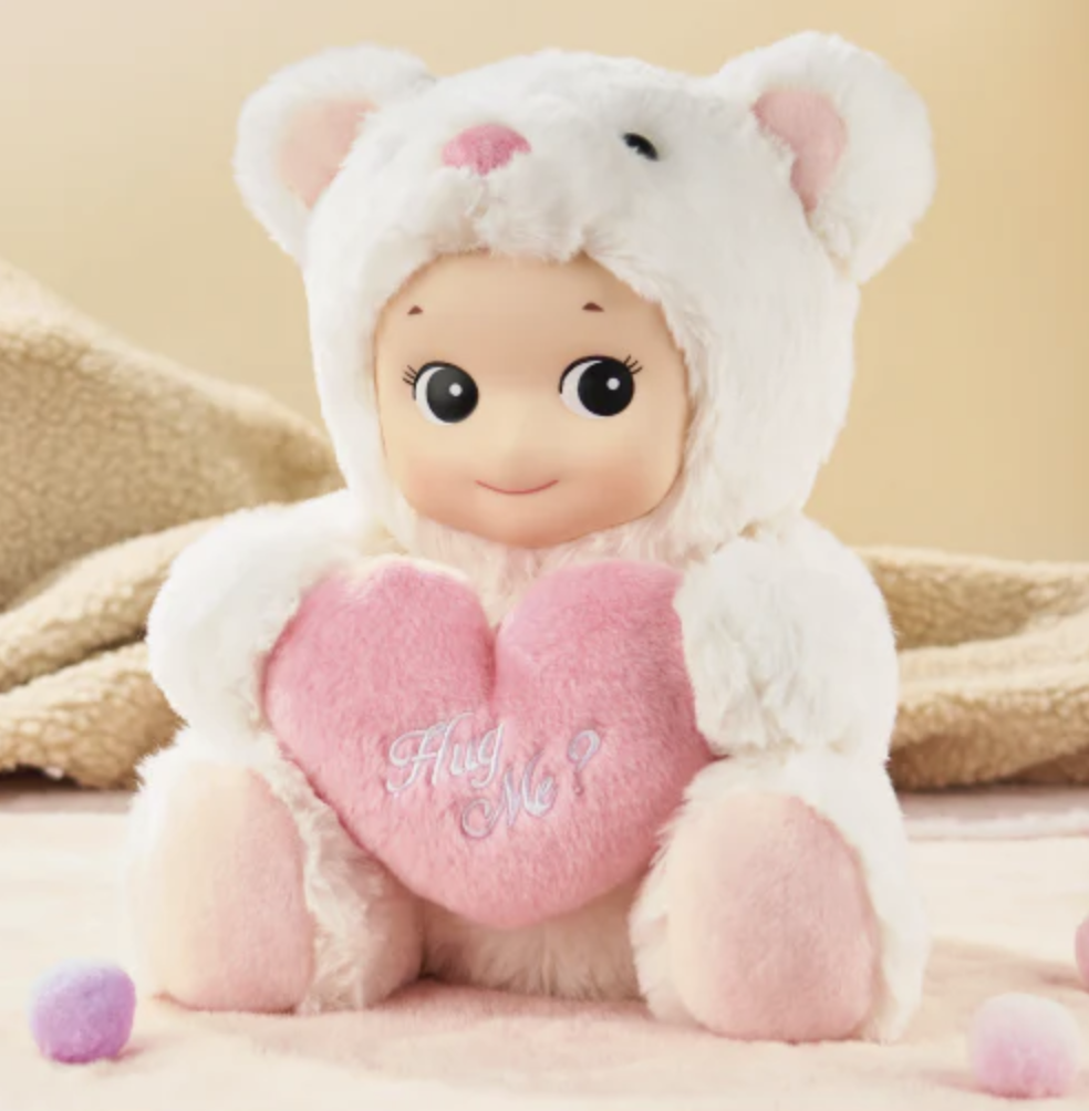 Sonny Angel White Cuddly Bear plush figure holding a pink plush heart that reads "Hug Me?' in white.
