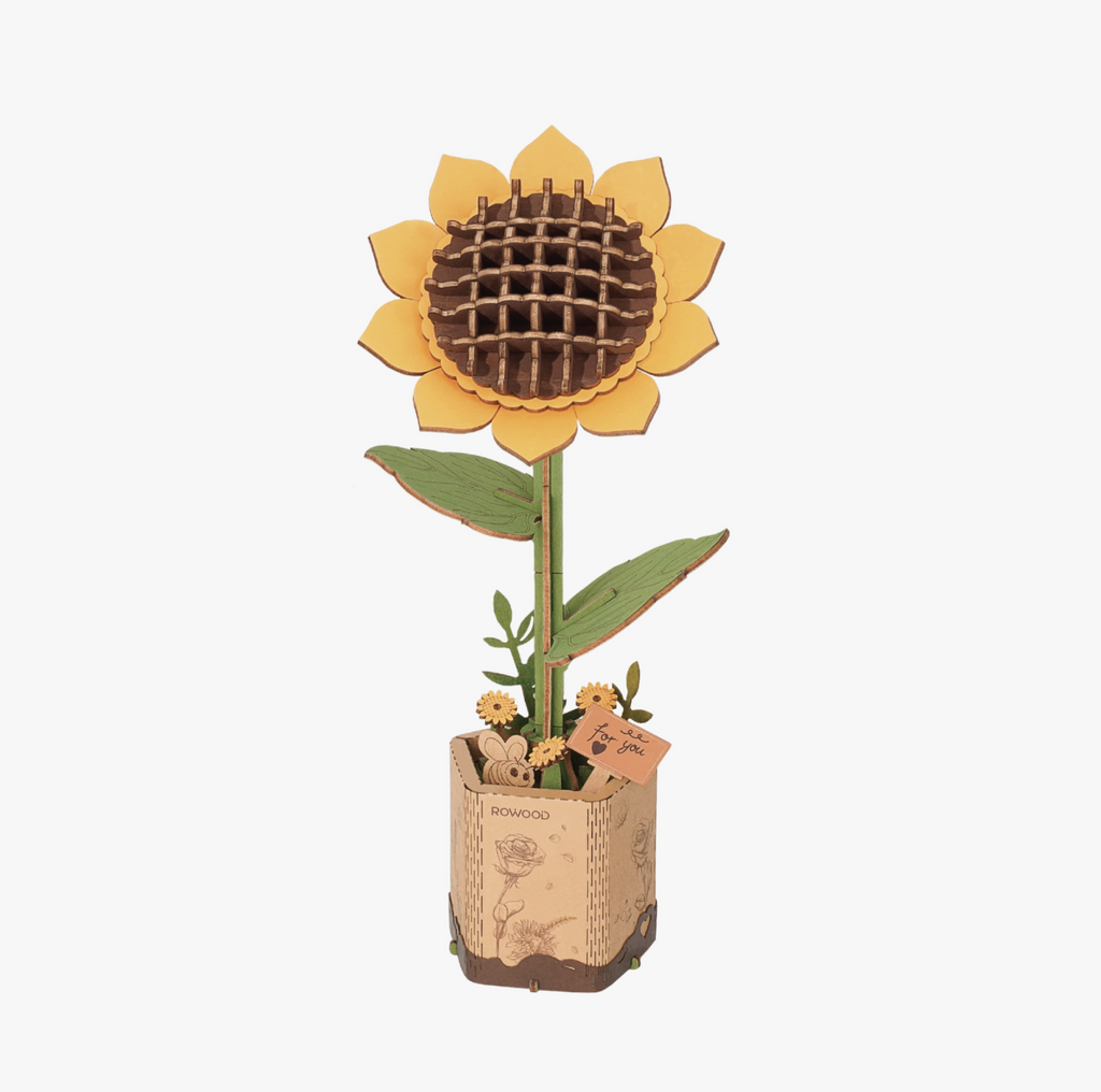 Assembled bright yellow sunflower 3D DIY wooden puzzle on cardboard base.