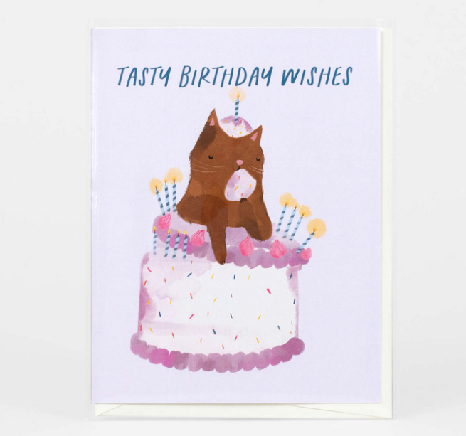 A kitty cat on top of a birthday cake with a candle on his head, the card reads "Tasty Birthday Wishes"