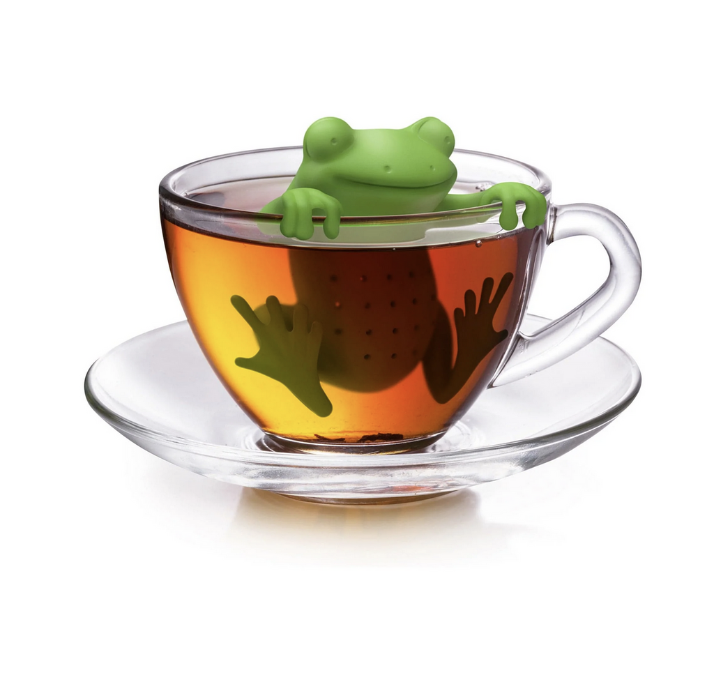Siliconr green frog shaped tea infuser in a glass mug of tea.