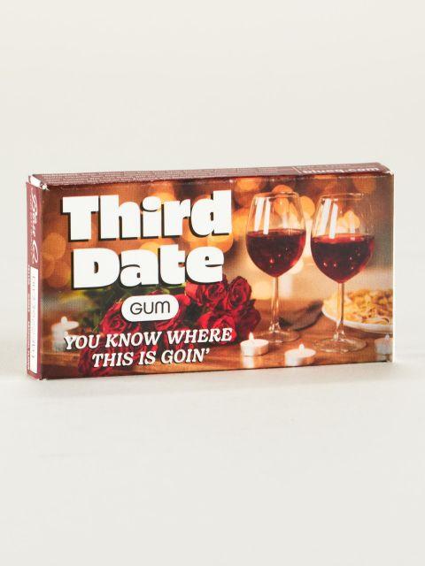 Box of the "Third Date Gum". The box has a background picture of a table set for two, with wine, roses, candles, and a plate of pasta. It reads, "Third Date Gum, You Know Where This Is Goin'" in white letters. 
