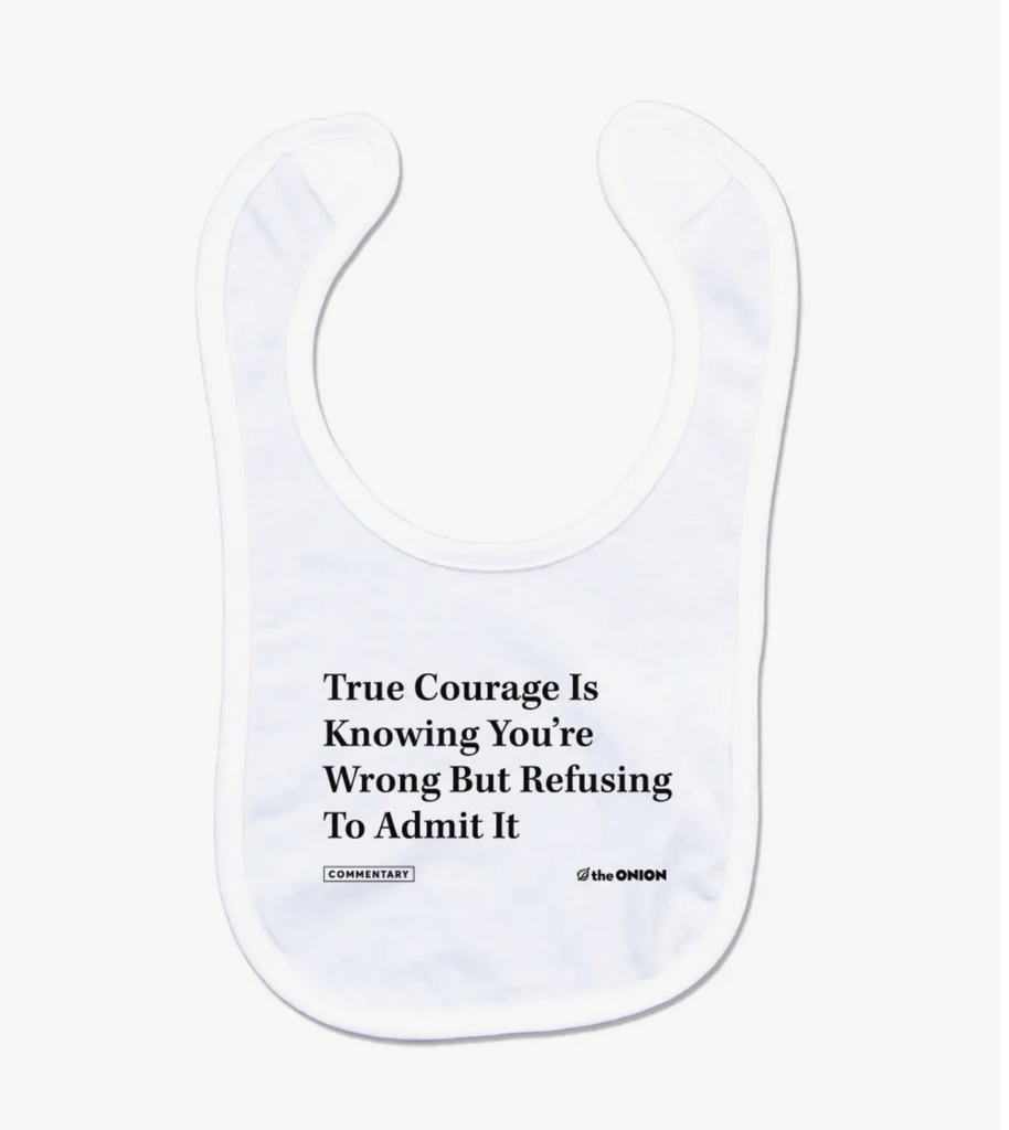 White cotton baby bib reads in bold black type true courage is knowing you're wrong but refusing to admit it. The Onion.