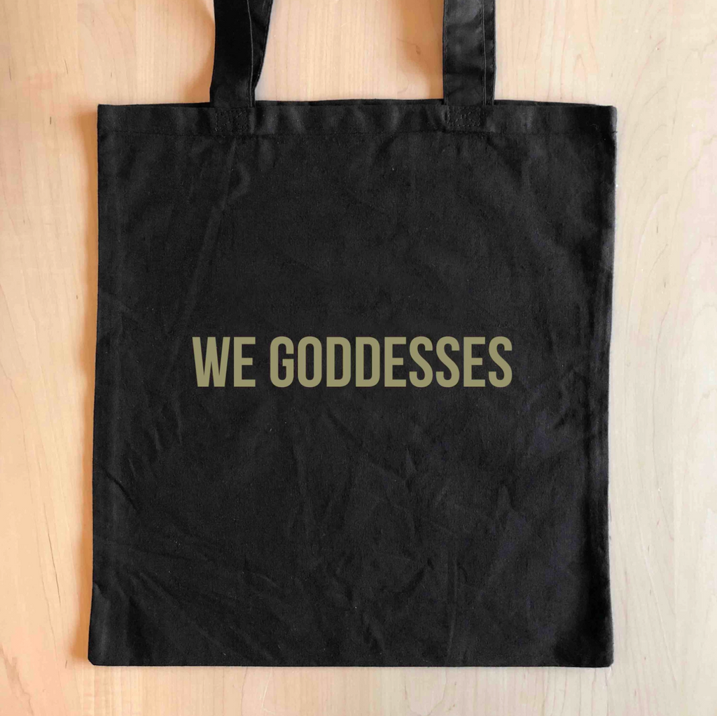 Black tote bag with gold text that reads "We Goddesses."