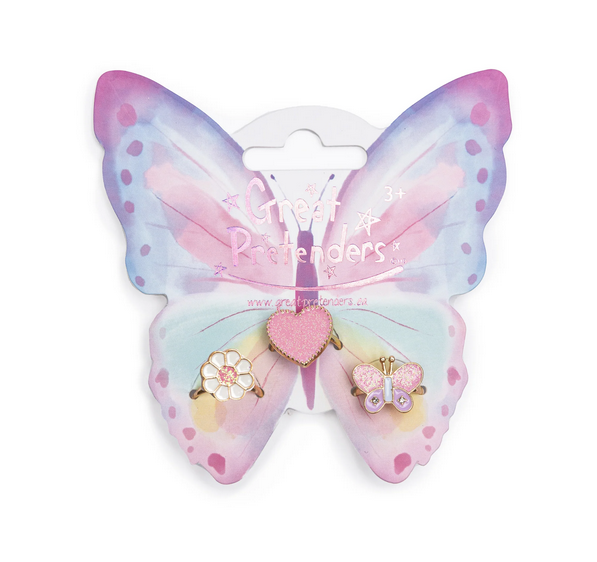 The Wonderland Ring set is made up of three rings displayed on a purple and pink butterfly card.  There is a pink glitter heart shaped ring, a flower with white petals and glittery pink center, and a butterfly with glittery pink and purple wings.  